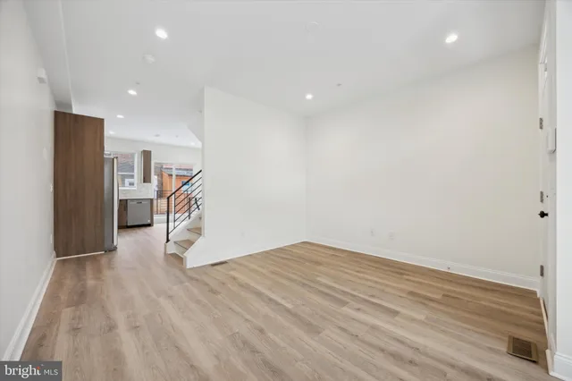 a view of empty room with wooden floor
