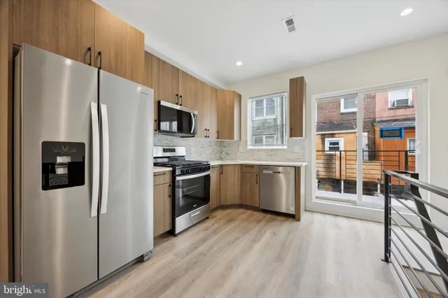 a kitchen with stainless steel appliances a refrigerator and a stove top oven