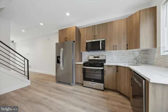 a kitchen with a sink a microwave a refrigerator and cabinets