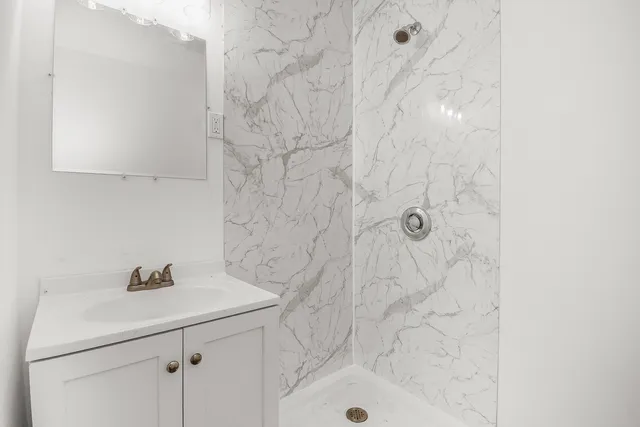 a bathroom with a shower sink and vanity