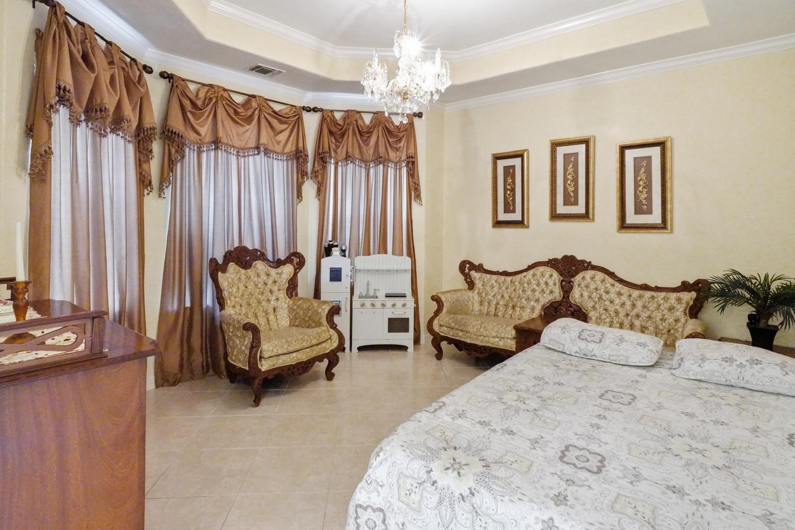 247 Old Spring Lane Houston, TX 77015 - Photo 8 of 25 a spacious bedroom with a bed and a chandelier