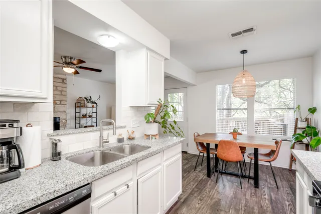 a kitchen with granite countertop a sink dining table and chairs
