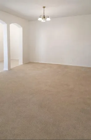 an empty room with chandelier fan