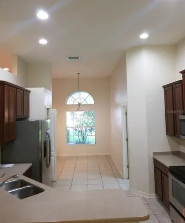 a view of a kitchen with a sink refrigerator and window