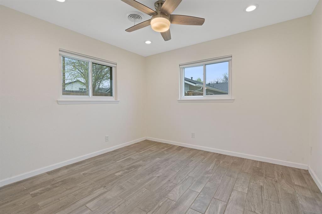 5211 Halmark Drive Austin, TX 78723 - Photo 12 of 27 Ceramic tile flooring spans this well-lit secondary bedroom, featuring a contemporary ceiling fan and dual windows.