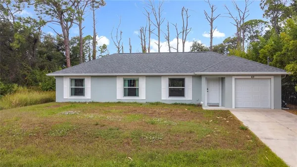 an aerial view of residential houses with outdoor space and trees