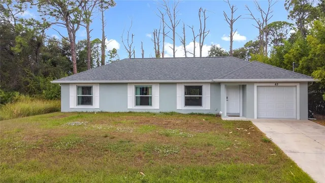 an aerial view of residential houses with outdoor space and trees
