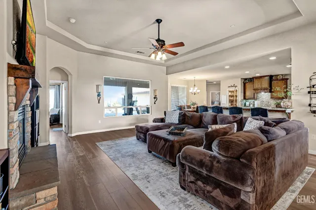 a living room with furniture kitchen view and a wooden floor
