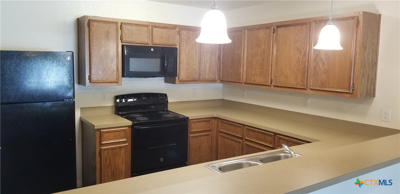 4606 Waterproof Drive, Unit A Killeen, TX 76549 - Photo 7 of 13 a kitchen with a sink and a refrigerator