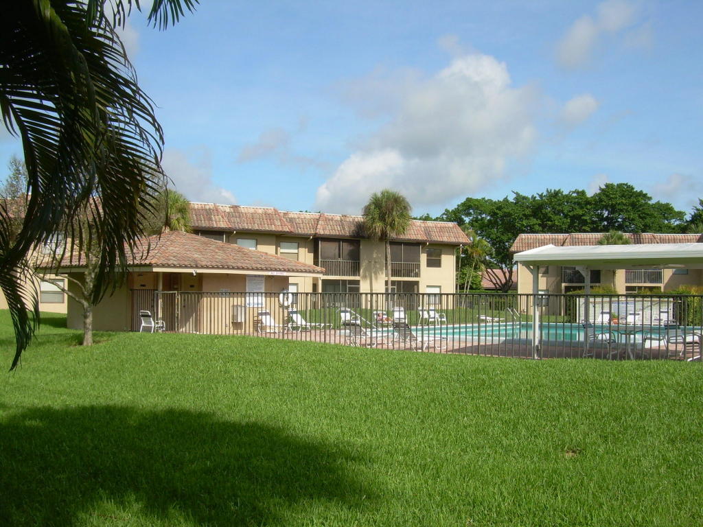 6772 Palmetto Circle South, Unit 104 Boca Raton, FL 33433 - Photo 14 of 17 a front view of house with yard and green space