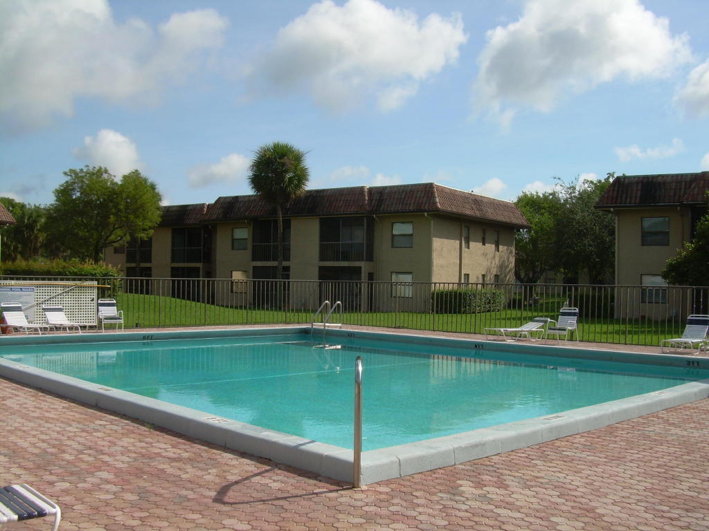 6772 Palmetto Circle South, Unit 104 Boca Raton, FL 33433 - Photo 15 of 17 a view of a house with a swimming pool and a yard