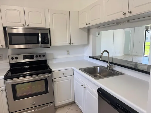 a kitchen with cabinets stainless steel appliances and a sink