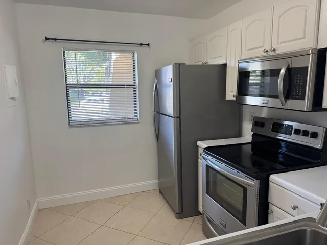 a kitchen with stainless steel appliances white cabinets and a stove top oven