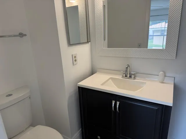 a bathroom with a sink toilet and mirror