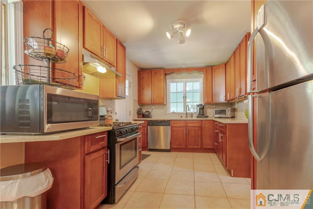 297 Washington Road Sayreville, NJ 08872 - Photo 15 of 44 a kitchen with stainless steel appliances granite countertop a refrigerator and a stove top oven