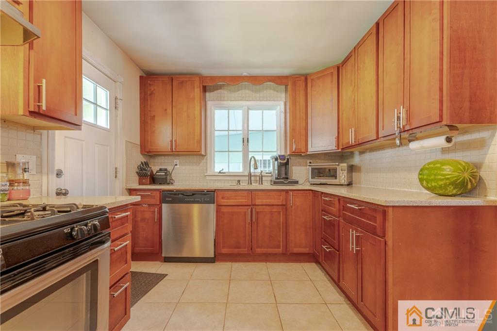 297 Washington Road Sayreville, NJ 08872 - Photo 16 of 44 a kitchen with stainless steel appliances granite countertop a stove a sink and a microwave