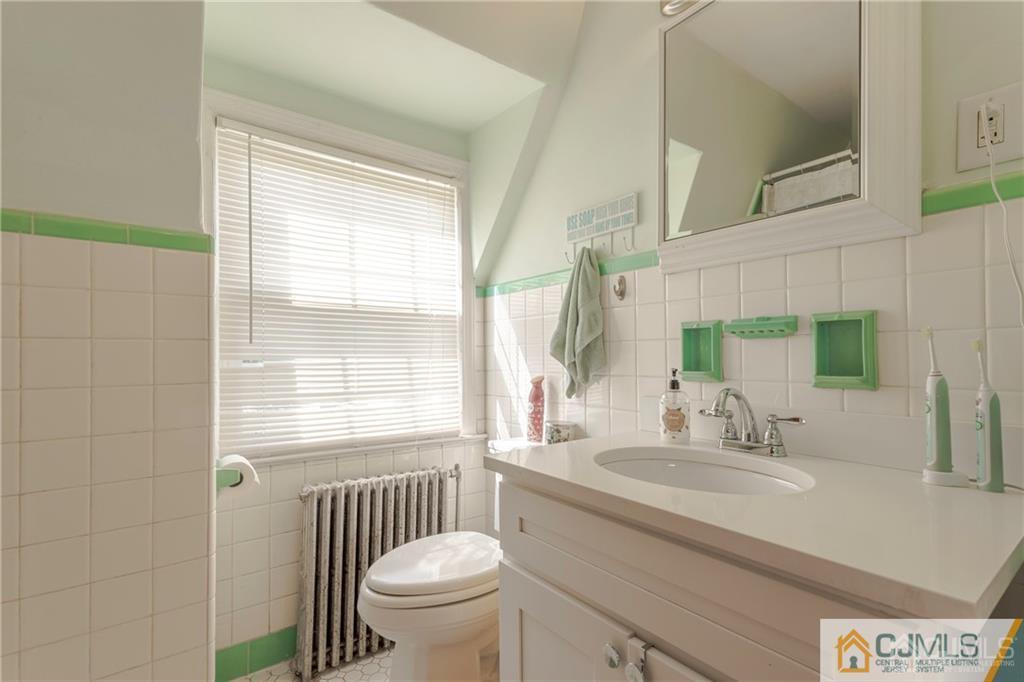 297 Washington Road Sayreville, NJ 08872 - Photo 26 of 44 a bathroom with a sink a toilet a mirror and a window