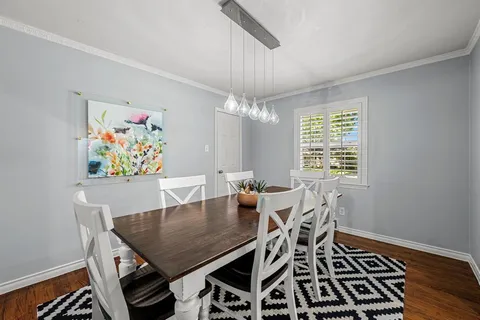 a view of a dining room with furniture a chandelier and wooden floor