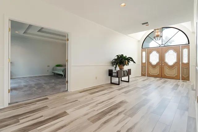 a spacious bedroom with a bed and a large window with balcony view