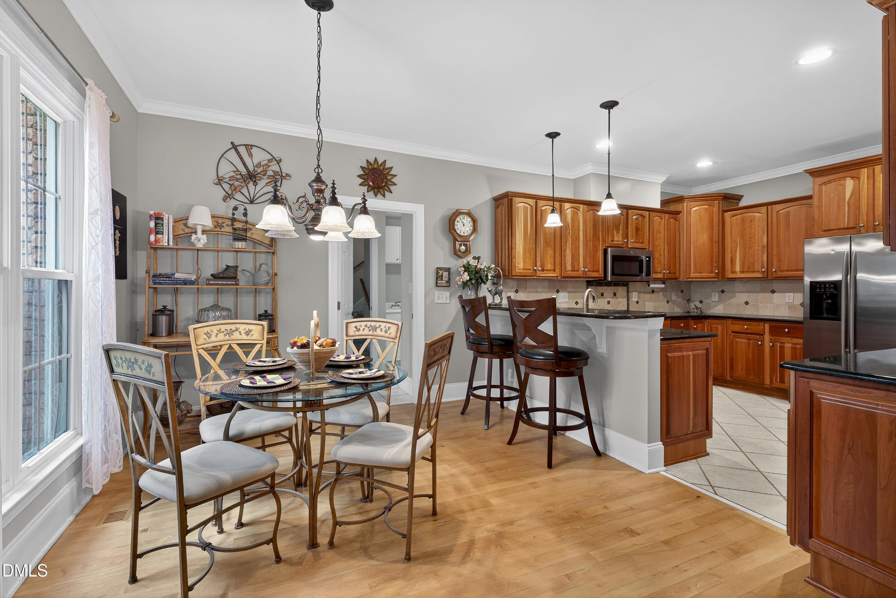 4613 Cross Brook Lane Raleigh, NC 27610 - Photo 17 of 53 a kitchen with stainless steel appliances kitchen island granite countertop a dining table chairs and a refrigerator