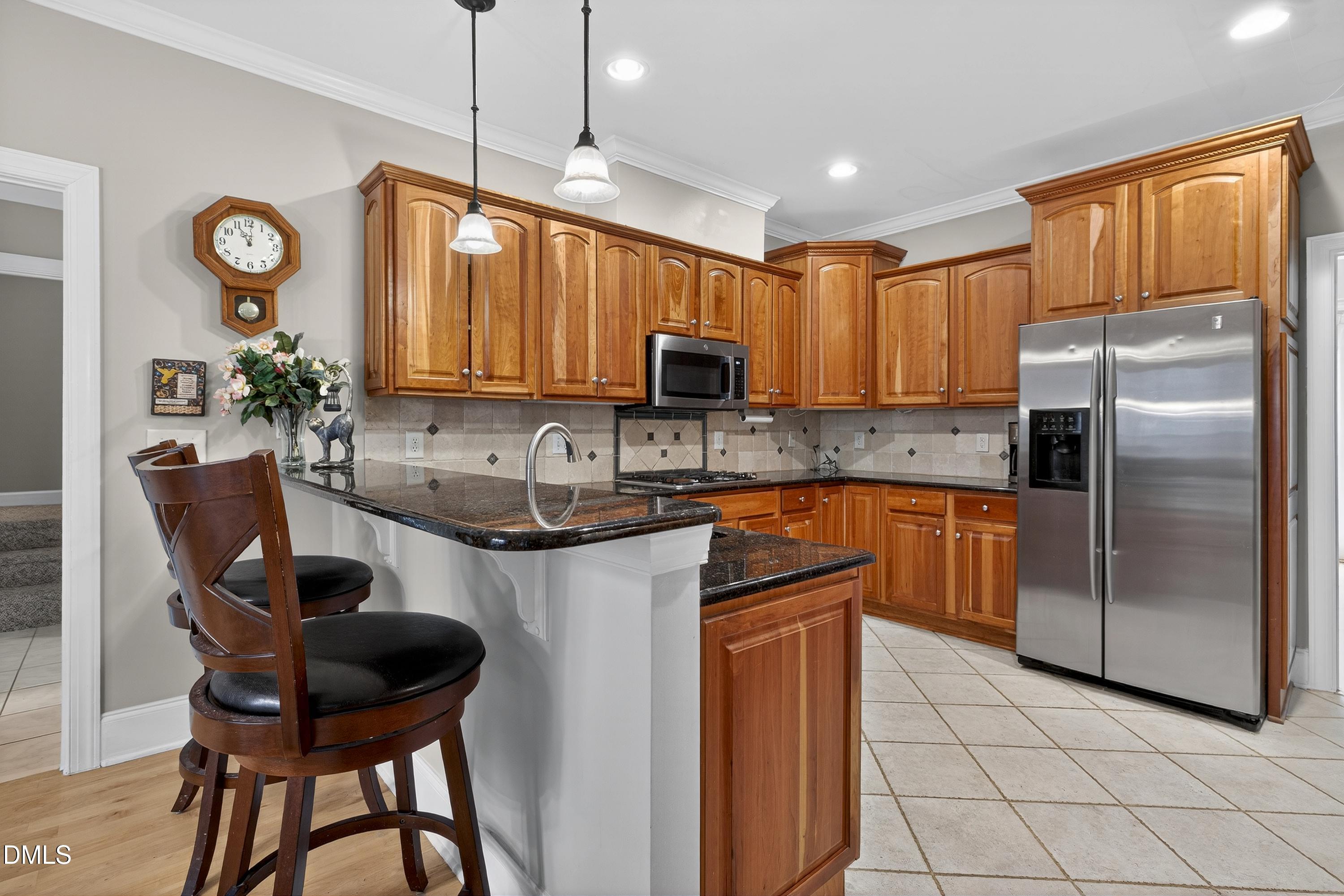 4613 Cross Brook Lane Raleigh, NC 27610 - Photo 20 of 53 a kitchen with a refrigerator a stove a sink and a cabinets