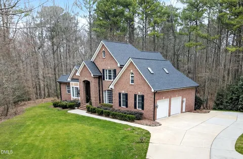 a front view of a house with a yard and trees