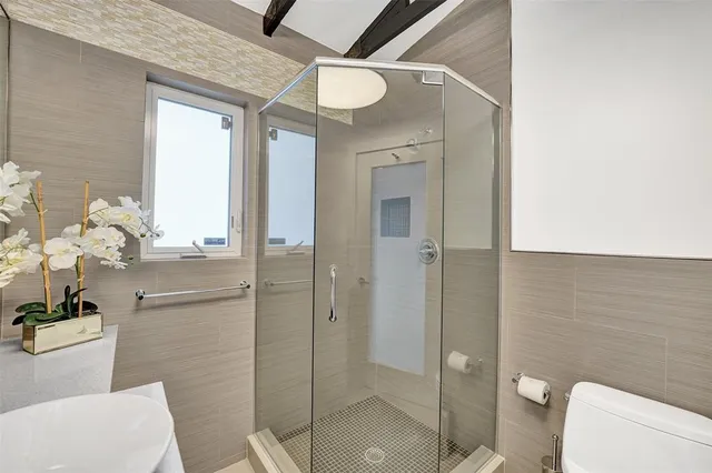 a bathroom with a granite countertop sink a toilet and shower