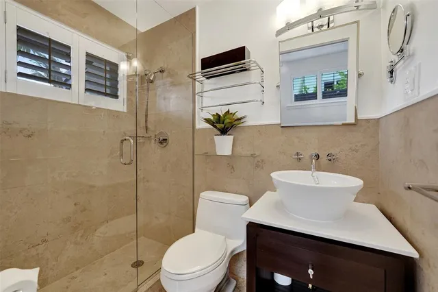 a bathroom with a sink a toilet and shower