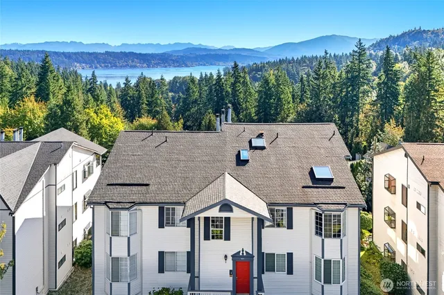 an aerial view of residential houses with a yard and mountain view in back