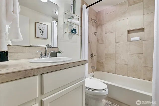 a bathroom with a granite countertop sink a toilet and shower