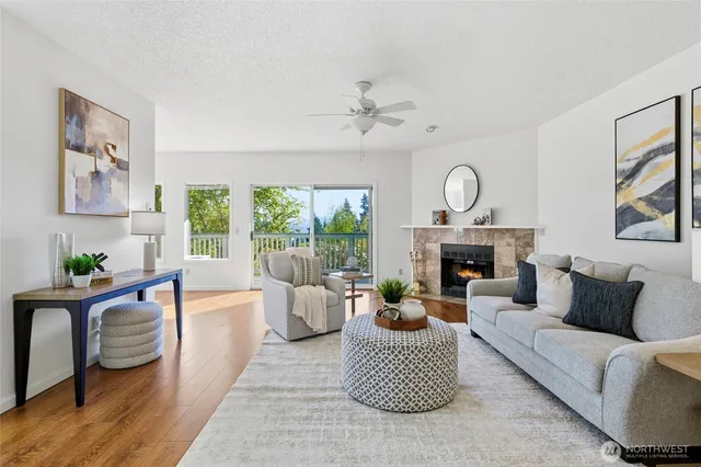 a living room with furniture a large window and a fireplace