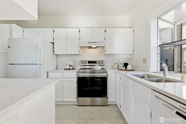 a kitchen with cabinets white stainless steel appliances and sink