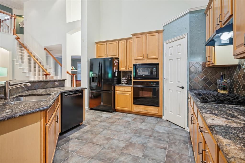 125 Bricknell Lane Coppell, TX 75019 - Photo 14 of 27 a kitchen with stainless steel appliances granite countertop a stove refrigerator and a sink