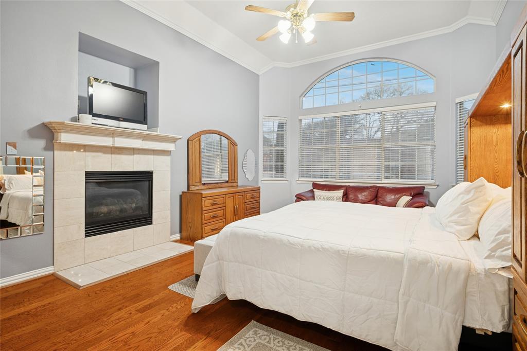 125 Bricknell Lane Coppell, TX 75019 - Photo 19 of 27 a bedroom with a bed and a fireplace