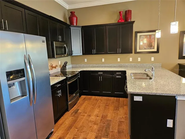 a kitchen with a sink a counter top space and living room view