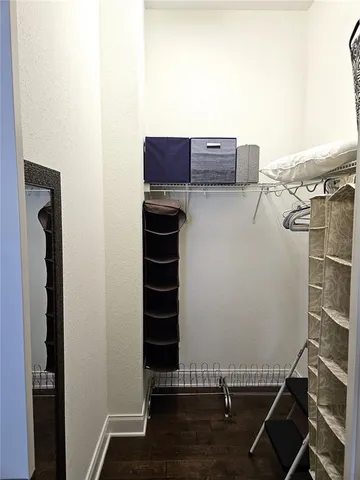 a view of a livingroom with wooden floor and a bathroom