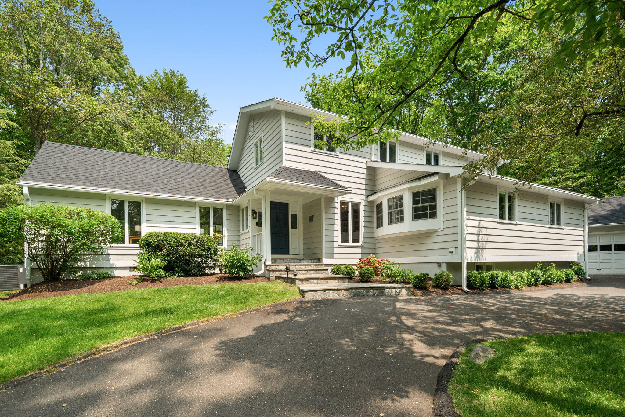 53 Fox Run Road New Canaan, CT 06840 - Photo 3 of 39 a front view of a house with a garden and plants