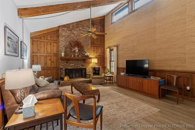 a living room with furniture a flat screen tv and a fireplace