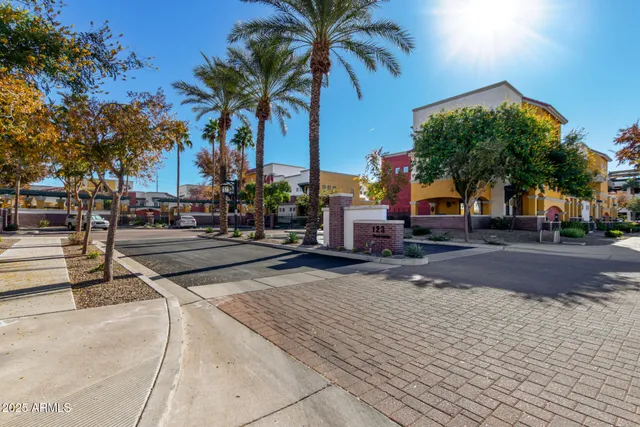 a view of a house with a yard and table and chairs under an umbrella