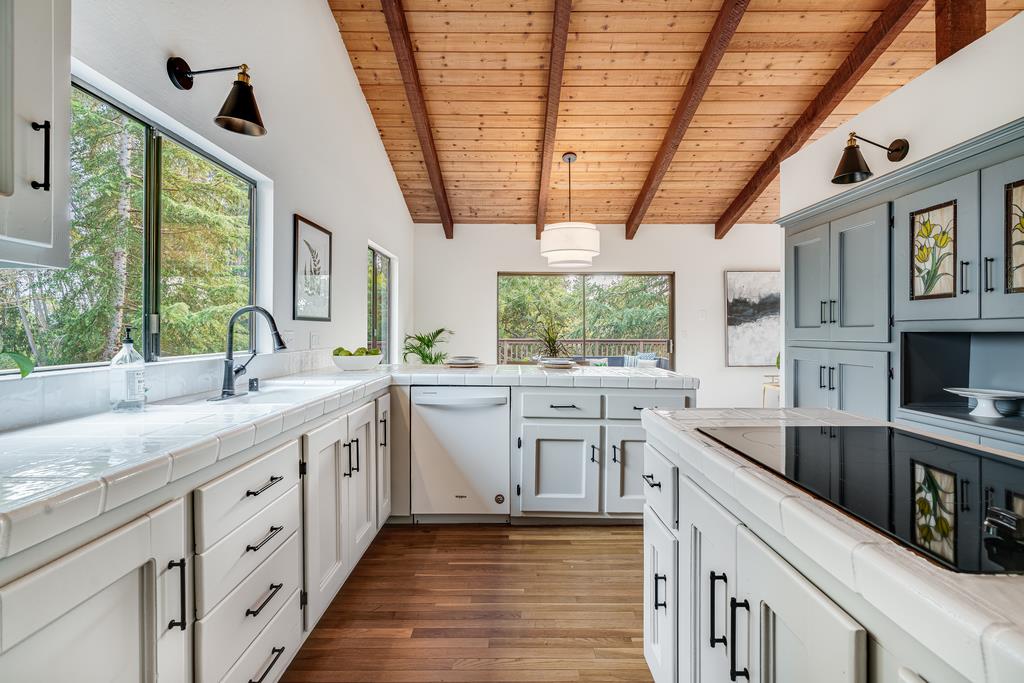 390 Brooktree Ranch Road Aptos, CA 95003 - Photo 16 of 33 a kitchen with white cabinets and wooden floors