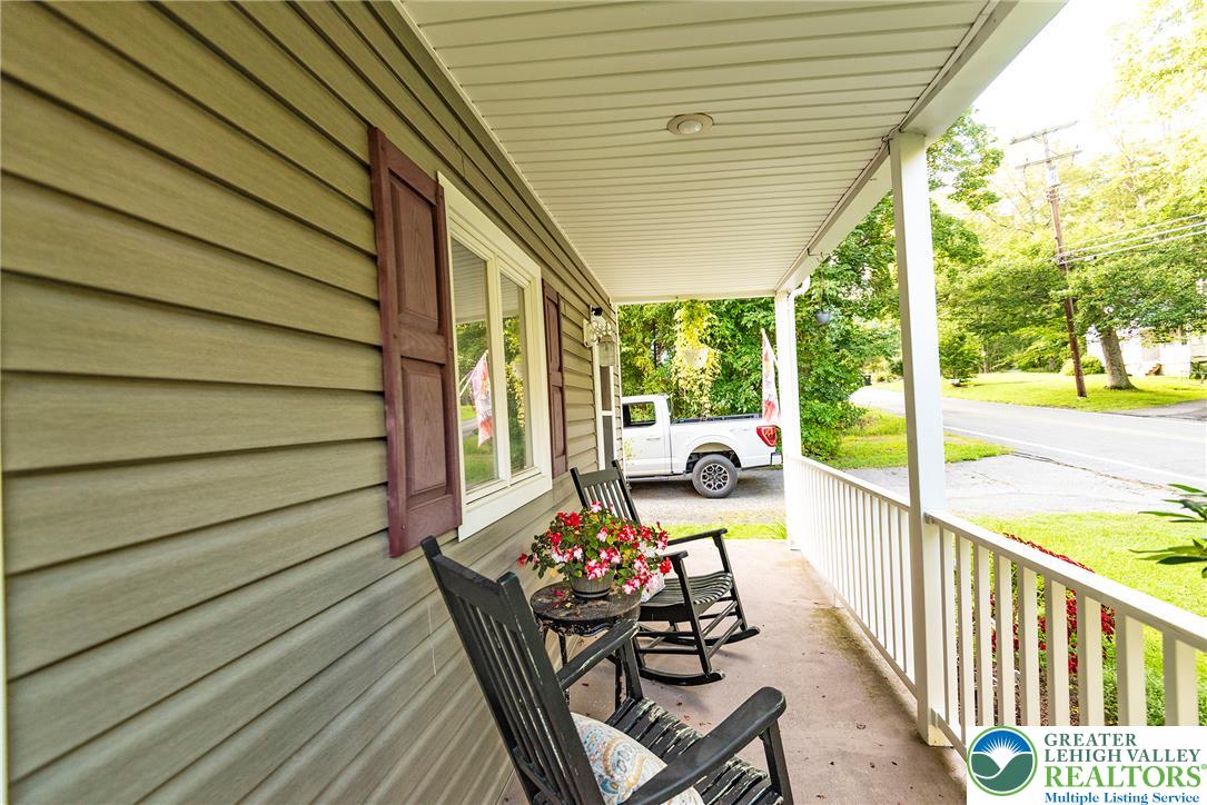 1114 Fox Gap Road Bangor, PA 18013 - Photo 10 of 63 An inviting covered porch provides a peaceful outdoor space bordered by classic railings.