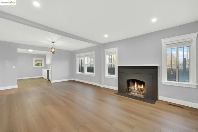 a view of an empty room with window and fire place
