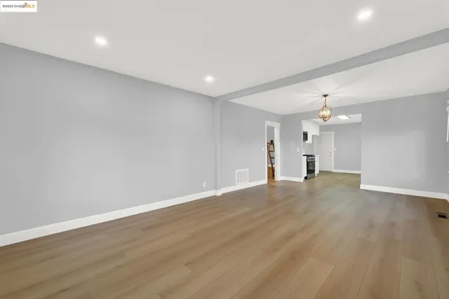 a kitchen with stainless steel appliances a sink dishwasher a stove top oven a refrigerator with grey cabinets and wooden floor