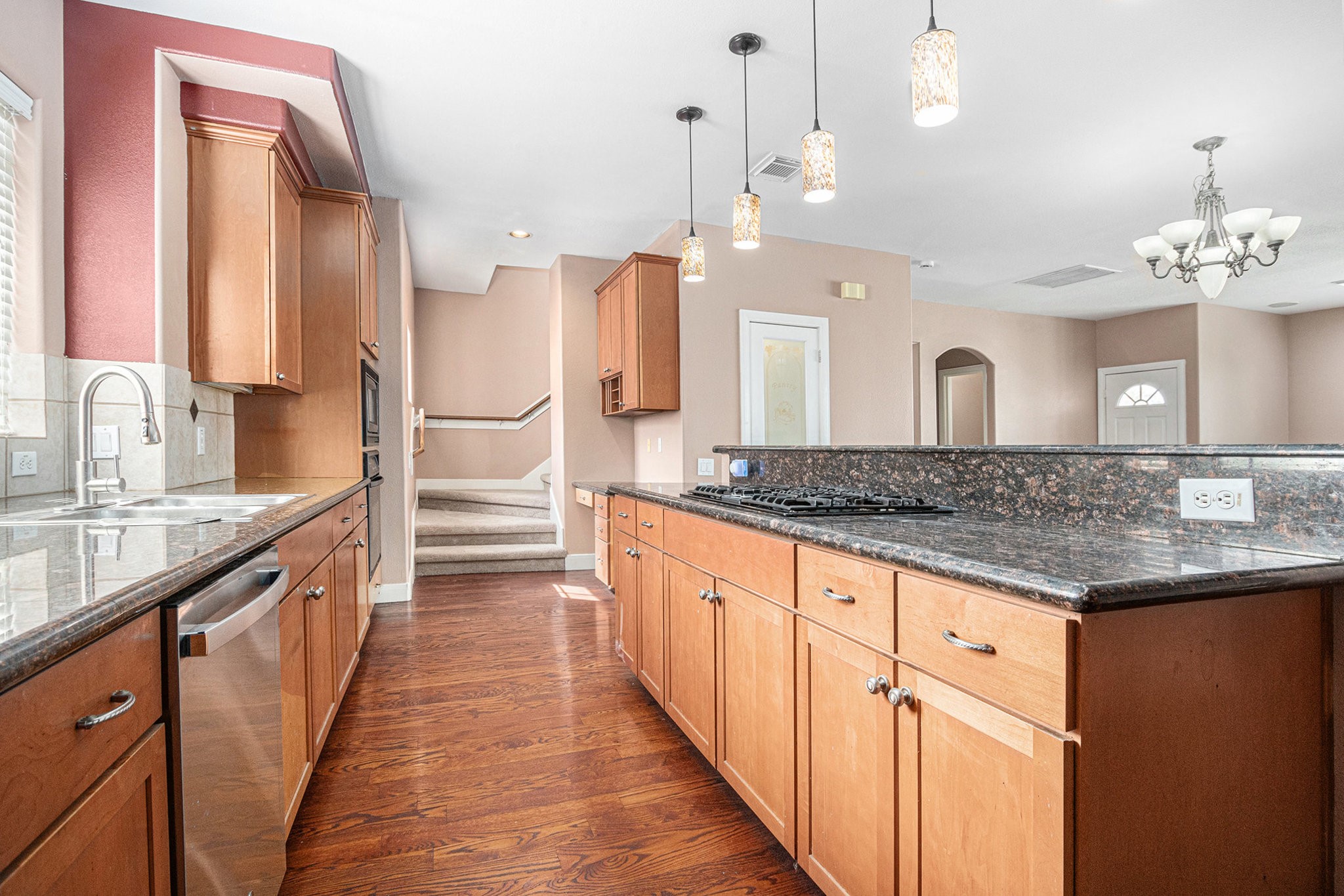 2402 Calumet Street, Unit B Houston, TX 77004 - Photo 15 of 40 a large kitchen with granite countertop a large kitchen island and a sink dishwasher refrigerator with wooden floor