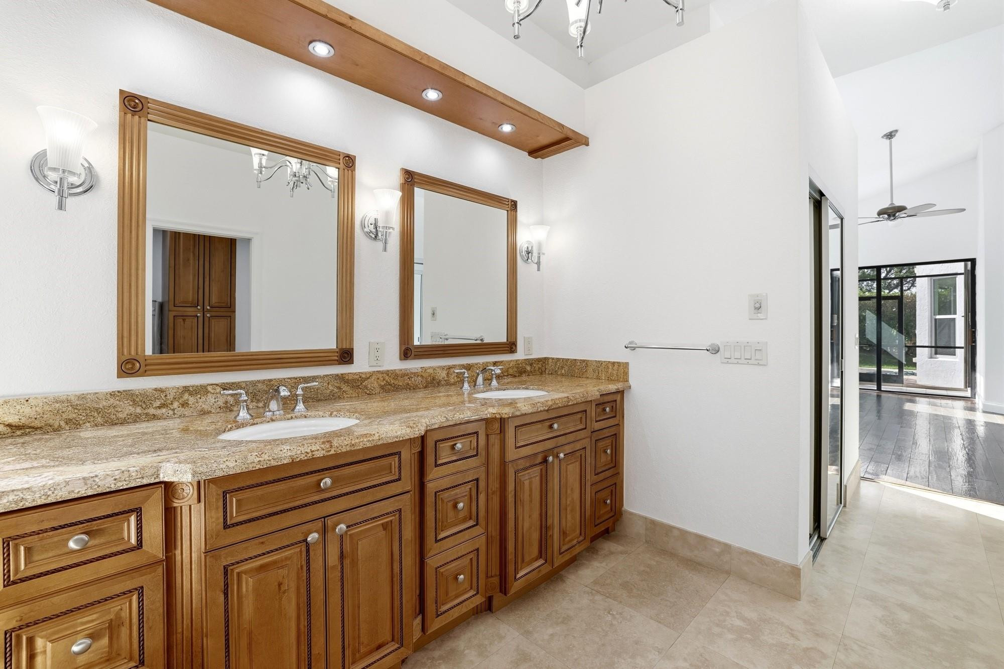 2498 Northwest 63rd Street Boca Raton, FL 33496 - Photo 17 of 39 a bathroom with a granite countertop double vanity sink and a mirror