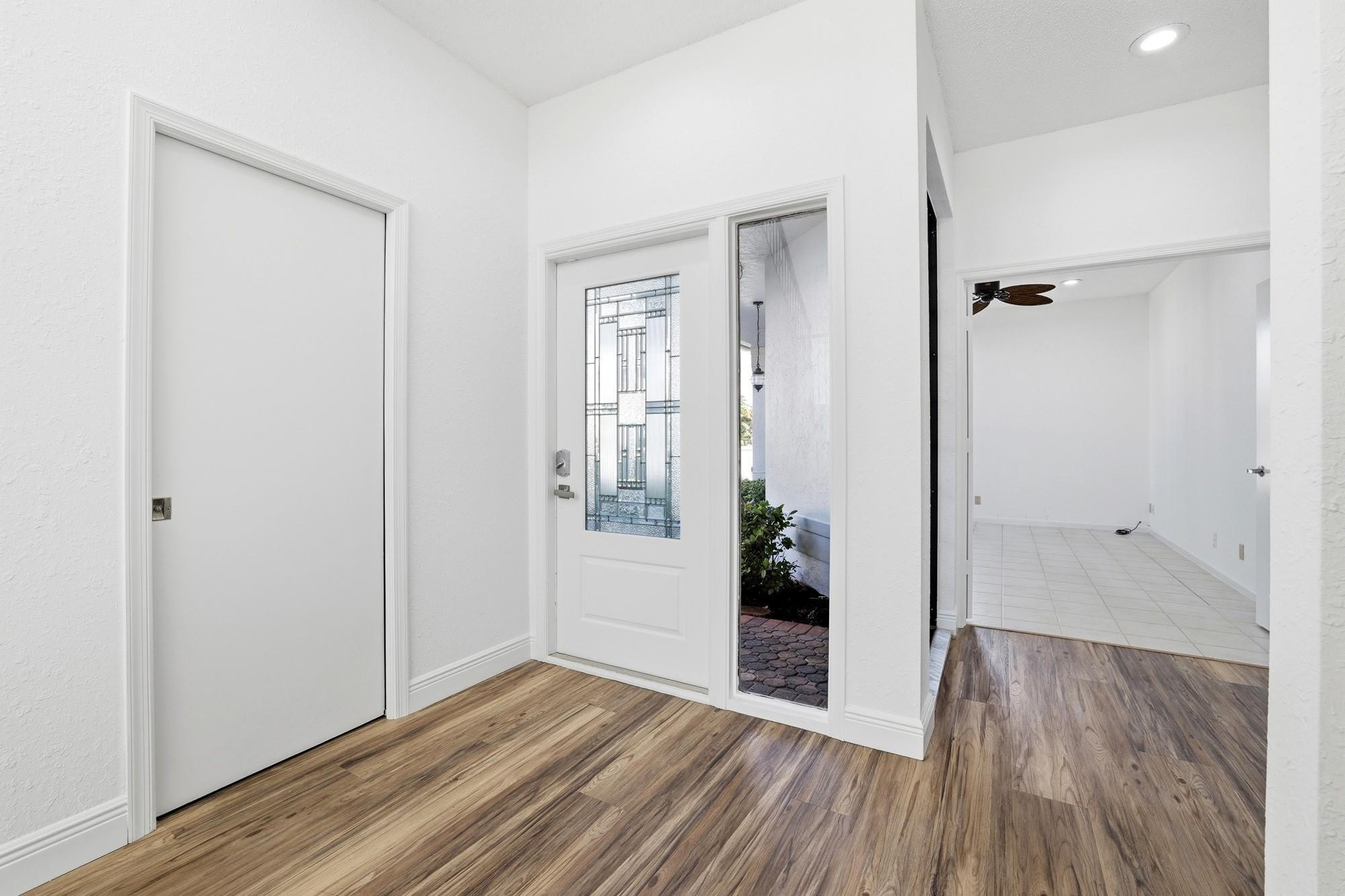 2498 Northwest 63rd Street Boca Raton, FL 33496 - Photo 20 of 39 a view of a hallway with wooden floor and a bathroom