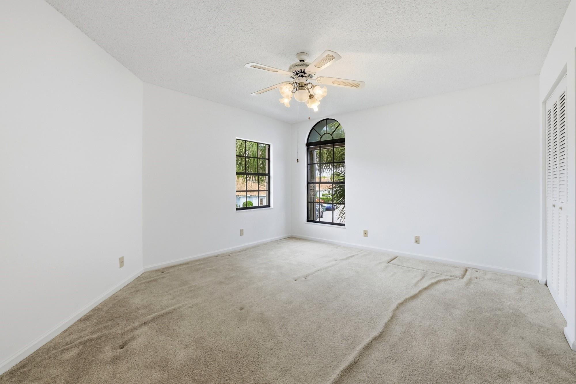 2498 Northwest 63rd Street Boca Raton, FL 33496 - Photo 22 of 39 an empty room with windows and chandelier fan
