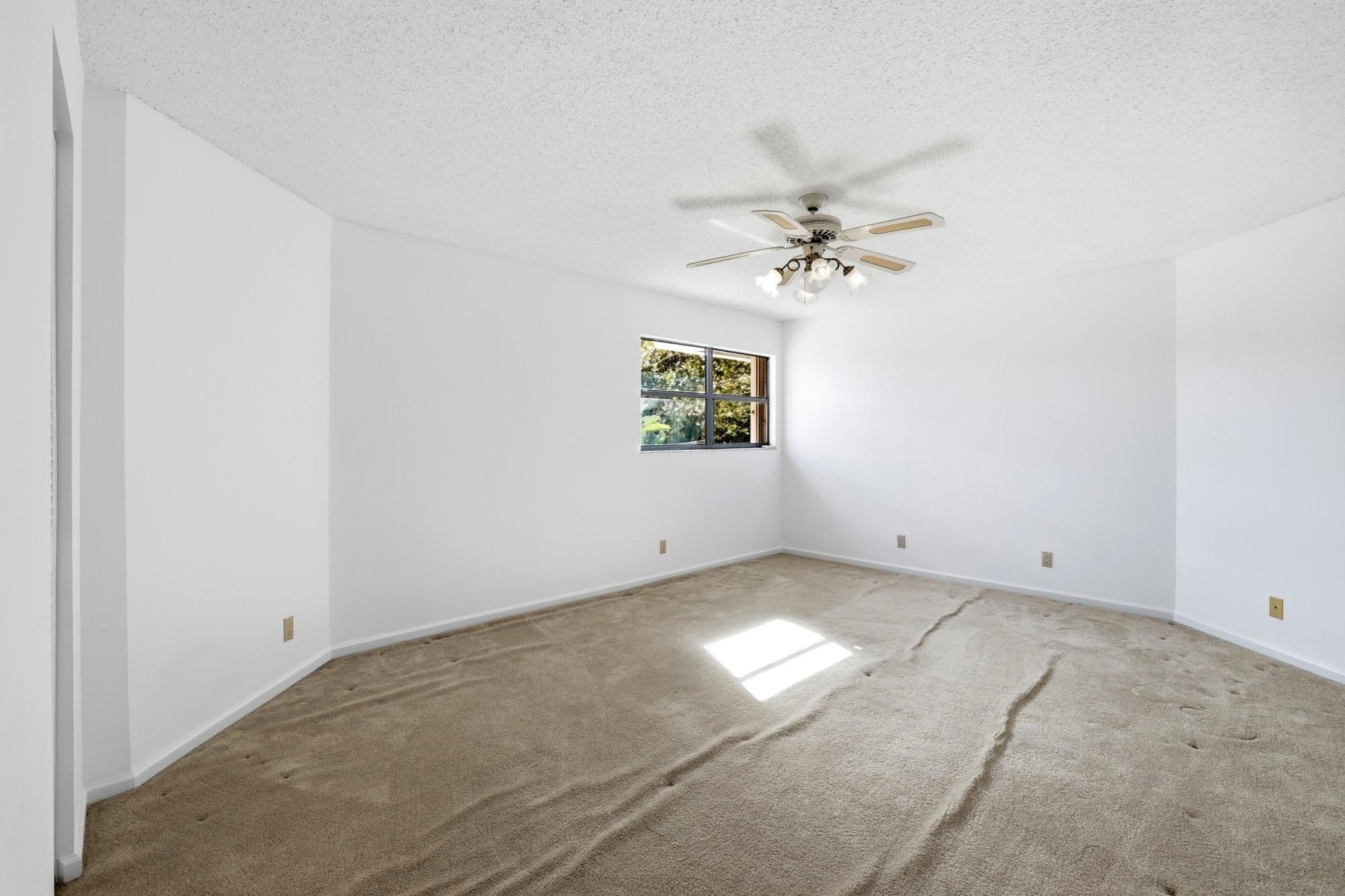 2498 Northwest 63rd Street Boca Raton, FL 33496 - Photo 24 of 39 an empty room with windows and chandelier fan