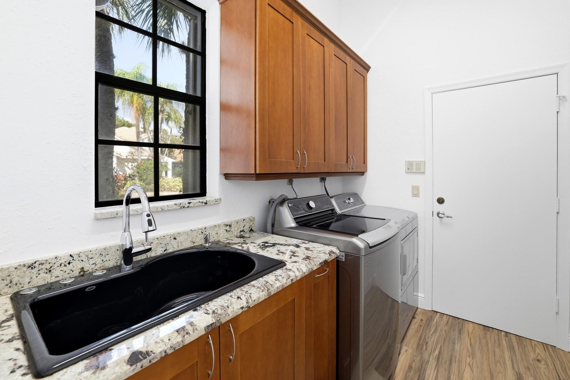 2498 Northwest 63rd Street Boca Raton, FL 33496 - Photo 25 of 39 a kitchen with a sink stove and cabinets