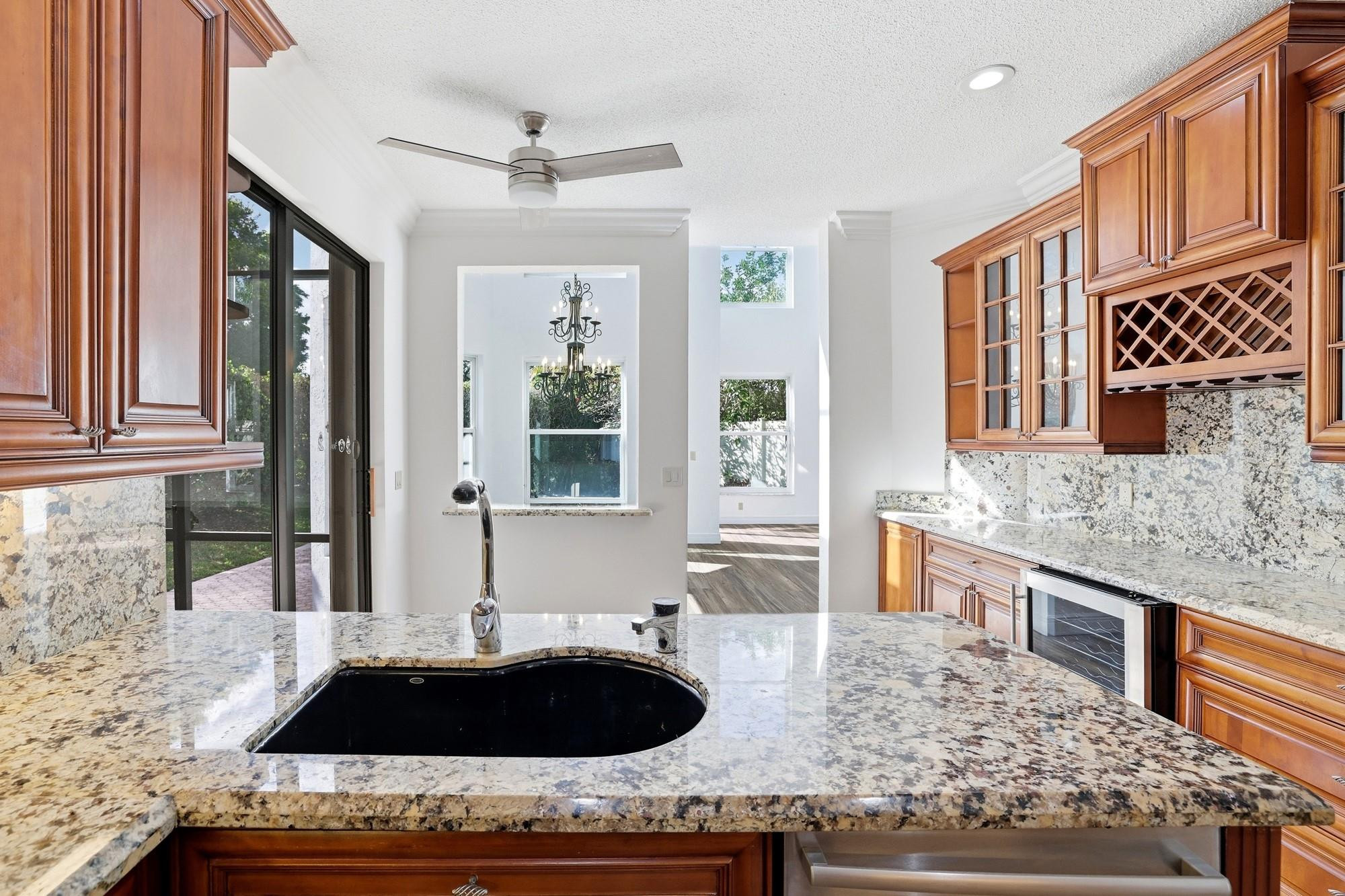 2498 Northwest 63rd Street Boca Raton, FL 33496 - Photo 9 of 39 a bathroom with a granite countertop sink and a bathtub